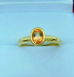 a yellow gold ring with an oval cut stone