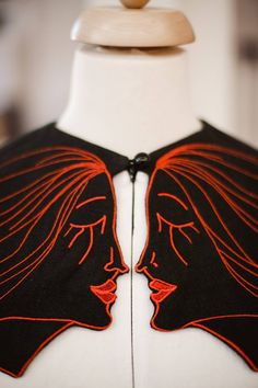 MIRRORED FACES COLLAR - BLACK imperial cotton collar; front button closure; embroidered with Lucia Olaru's vision and signature of the brand; the embroidery is made out with red metallic thread. Composition: 100% imperial cotton. Luxury Embroidered Outerwear With Mandarin Collar, Elsa Schiaparelli Embroidery, Luxury Accessories Woman, Luxury Modernist Necklace With Large Pendant, Luxury Black Statement Brooch, Schiaparelli Trompe L'oeil, Metallic Thread, Luxury Women, Making Out