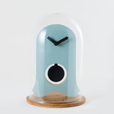 a clock that is on top of a wooden base with a glass dome over it