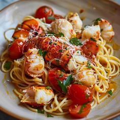 a plate of pasta with lobster, tomatoes and parmesan cheese