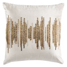 a white pillow with gold sequins on it