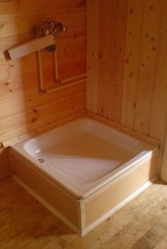 a bathroom with wood paneling and a white bathtub