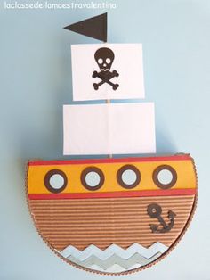 a paper boat with a skull on it and a pirate flag sticking out of the top