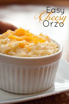 a white bowl filled with macaroni and cheese sitting on top of a plate