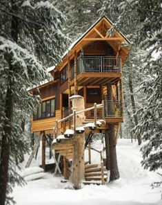 a tree house in the snow surrounded by trees