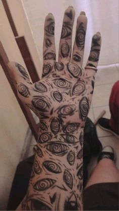 a person's hand with black and white tattoos on it