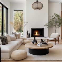 a living room with white furniture and a fire place in the fireplace area is shown