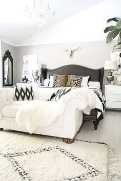 a white and black bedroom with lots of pillows