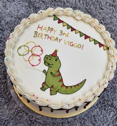 a birthday cake with an image of a dinosaur on it