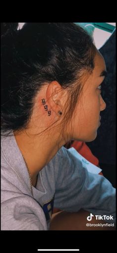 a woman with a small tattoo on her left ear