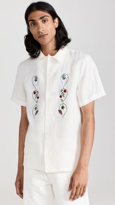 Find DE BONNE FACTURE Linen Embroidered Camp Collar Short Sleeve Shirt on Editorialist. Fabric: Lightweight, non-stretch linen weave. Floral and fruit embroidery at front. Camp collar and button placket. Short sleeves. Shell: 100% linen. Wash cold or dry clean. Made in Portugal. Measurements: Measurements from size M Length: 28in / 71cm Chest: 41in / 104cm Fitted Embroidered Top With Spread Collar, Summer Embroidered Shirt With Spread Collar, Embroidered Summer Shirt With Spread Collar, Embroidered Spread Collar Shirt For Summer, Embroidered Camp Collar Shirt For Summer, White Embroidered Summer Camp Shirt, Summer Embroidered Top With Camp Collar, Embroidered Camp Collar Tops For Summer, White Embroidered Camp Shirt For Summer