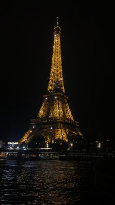 the eiffel tower lit up at night with lights on it's sides