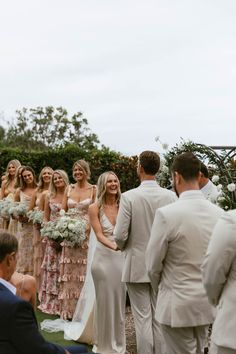 a group of people standing next to each other in front of a man and woman