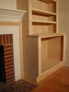 an empty room with a fireplace and shelves