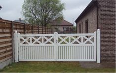 a white fence in front of a brick building