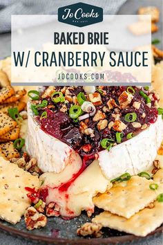 baked brie with cranberry sauce and crackers on a black platter