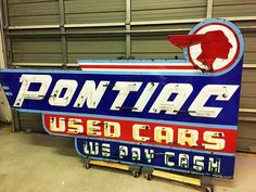 an old pontiac used cars sign in a garage