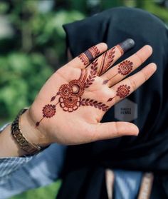 a woman's hand with henna tattoos on it