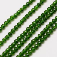 green beads are lined up on a white surface