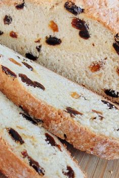 sliced loaf of bread sitting on top of a wooden cutting board with raisins