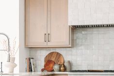 a kitchen with wooden cabinets and white counter tops, along with a cutting board on the stove