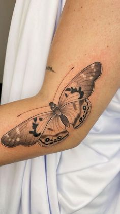 a woman's arm with a butterfly tattoo on it