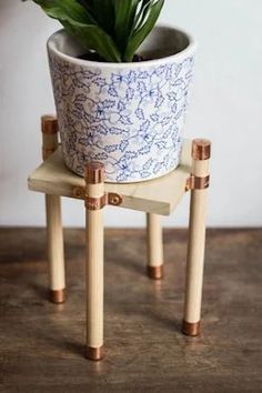 a potted plant sitting on two wooden legs