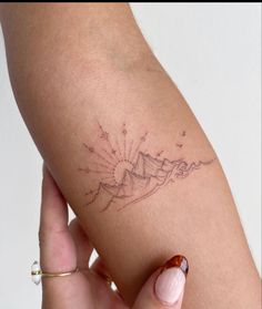 a woman's arm with a small tattoo on the left side of her arm