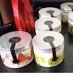 several jars filled with food sitting on top of a black table next to a red bag