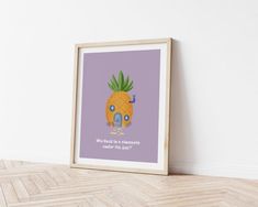 a framed poster on the wall with a house and pineapple in front of it