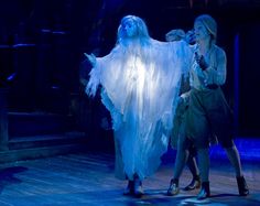 two women dressed as ghostes on stage with one holding the other's hand