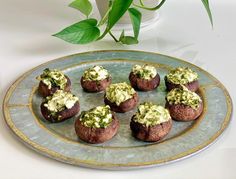 small stuffed mushrooms with green sauce on a plate