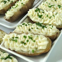 three trays filled with baked potatoes topped with cream cheese and chives on them