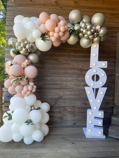 balloons are arranged in the shape of letters and numbers on a porch with greenery