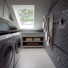 a washer and dryer in a small room with skylights on the windows