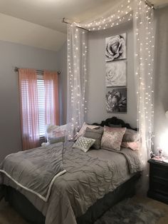 a bed with white sheets and lights hanging from it's headboard in a bedroom