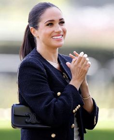 a woman with her hands folded and smiling