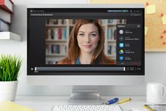 a computer screen with a woman's face on it and bookshelves in the background