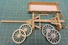 a wooden cart with wheels on a cutting board next to another wheel that is attached to the cart