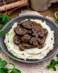 mashed potatoes topped with mushrooms and gravy on a plate