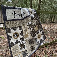 a quilt hanging on a wooden fence in the woods with words farm fresh written on it