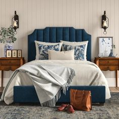 a bed with blue headboard and foot board next to two nightstands on either side