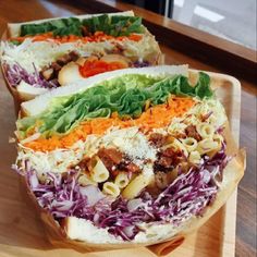 two sandwiches with different toppings on a wooden tray