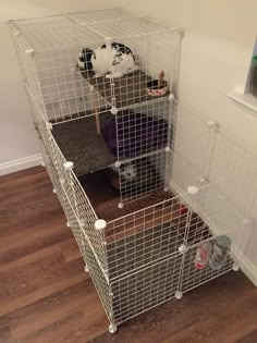 three cages are stacked on top of each other in the corner of a room with wood flooring