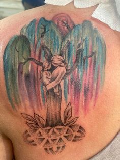 the back of a woman's shoulder with an angel tattoo on it