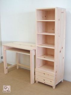 a wooden desk and bookcase in a room with white walls, beige flooring and tan carpet