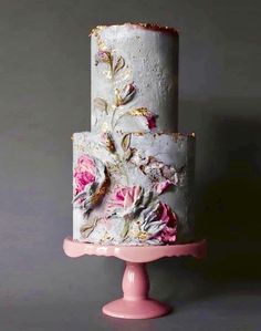 a three tiered cake with flowers painted on it