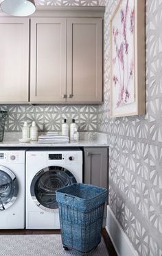 a washer and dryer in a small room with wallpaper on the walls