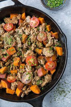 a skillet filled with meat and vegetables