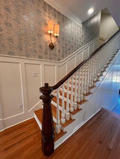 the stairs in this house are made of wood and have white balconies on them